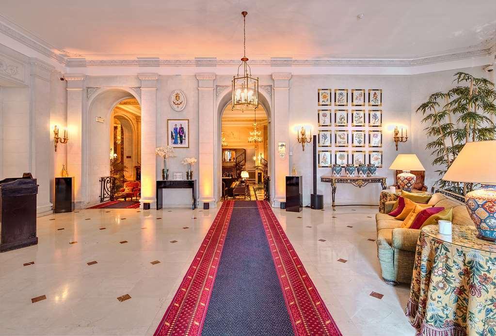 布鲁塞尔广场酒店  内观 照片 The photo shows an elegant and spacious hallway or entrance area of a home. The space features high ceilings and detailed architectural elements, such as arches. There is a long, decorative red carpet running down the center, flanked by polished marb