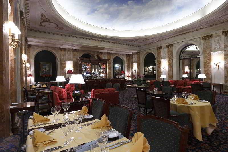 布鲁塞尔广场酒店  外观 照片 The photo depicts an elegant restaurant interior. The space features ornate decor, with a large, beautifully painted ceiling that gives an open and airy feel. The walls are adorned with rich textures and possibly artwork. 

Tables are set with yellow