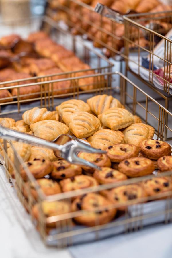 布鲁塞尔广场酒店  外观 照片 The photo shows a display of baked goods in a basket. There are two types of pastries: one variety appears to be flaky and golden-brown with a distinctive wavy pattern, while the other variety consists of circular pastries with a swirled design that 